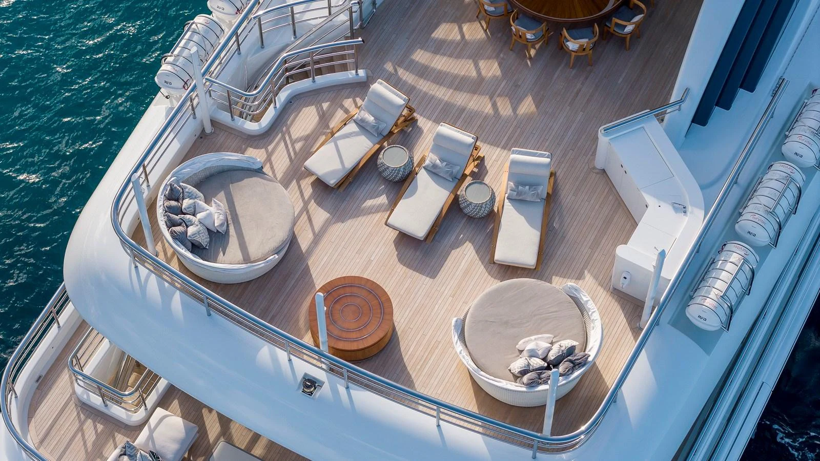 The sundeck offers luxurious lounging areas with sunbeds and circular seating arrangements. aboard NENINKA Yacht for Sale