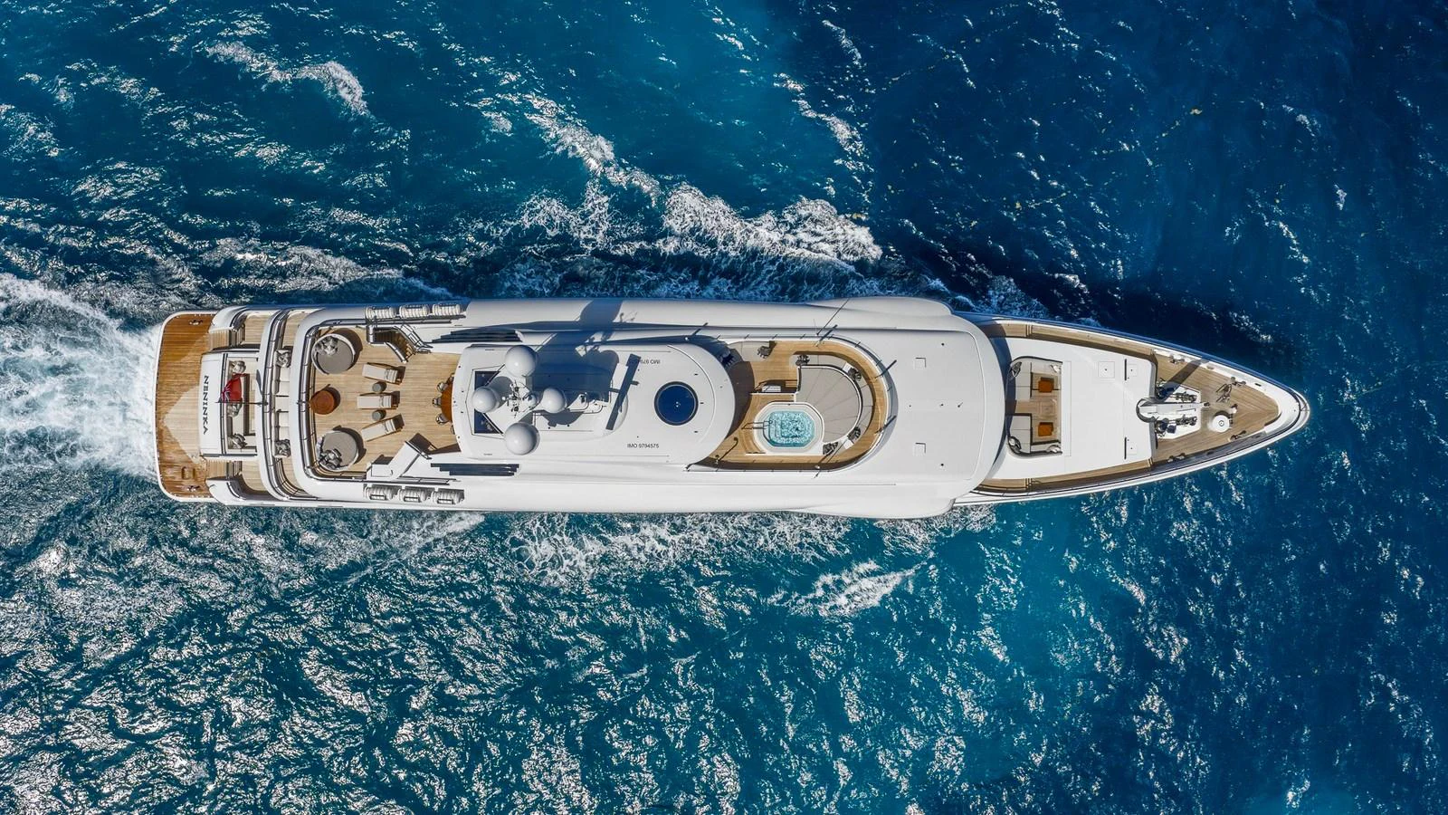 An aerial view of a luxurious yacht cruising through vibrant blue waters. aboard NENINKA Yacht for Sale