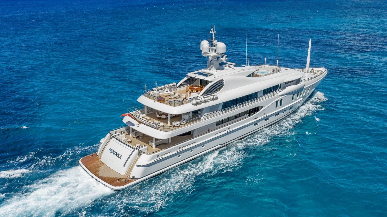 A luxurious yacht cruises through pristine blue waters, showcasing its elegant design and spacious decks. aboard NENINKA Yacht for Sale