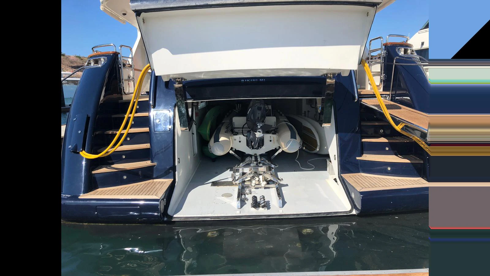 The yacht's garage is open, revealing stored equipment and water toys. aboard ALBATROSS Yacht for Sale