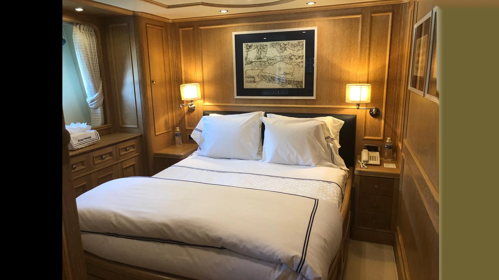 A cozy stateroom with warm wood paneling and soft lighting. aboard ALBATROSS Yacht for Sale