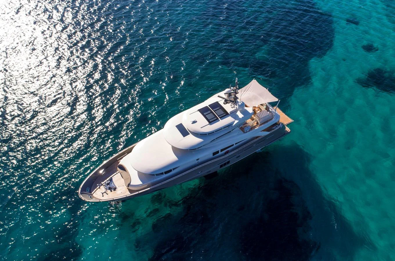 A sleek and modern yacht glides gracefully over crystal-clear waters, showcasing its elegant design. aboard MAXIMA Yacht for Sale