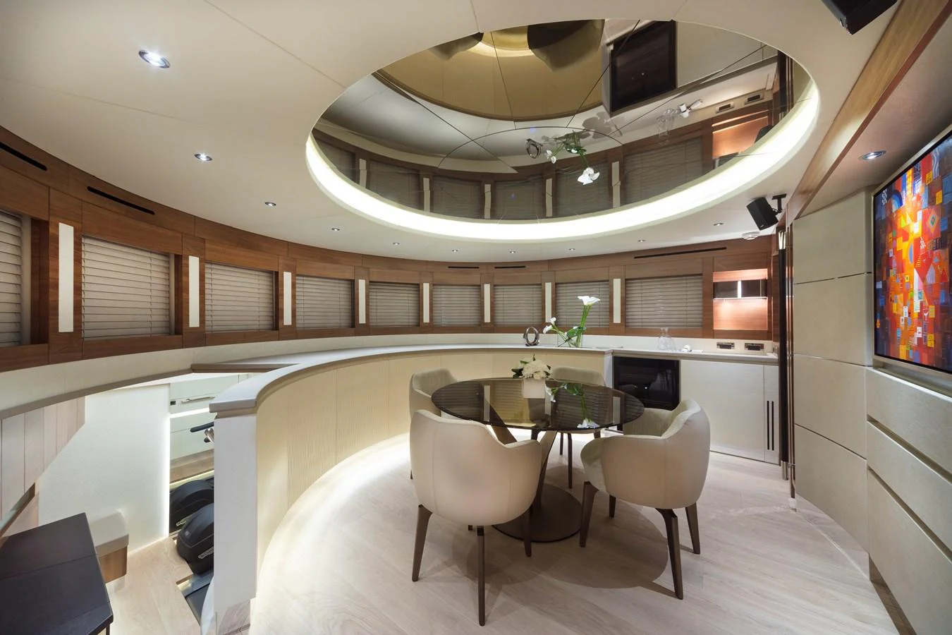 The yacht's dining area features a modern, circular design with elegant furnishings and ambient lighting. aboard MAXIMA Yacht for Sale