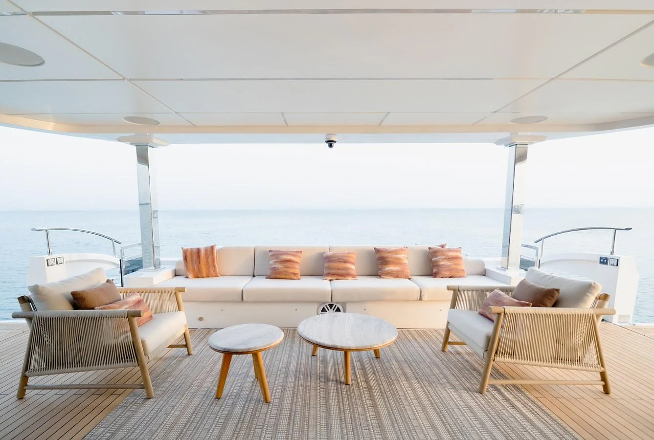 The aft deck features a comfortable seating area with a serene ocean view. aboard MAJESTY 100 TERRACE Yacht for Sale