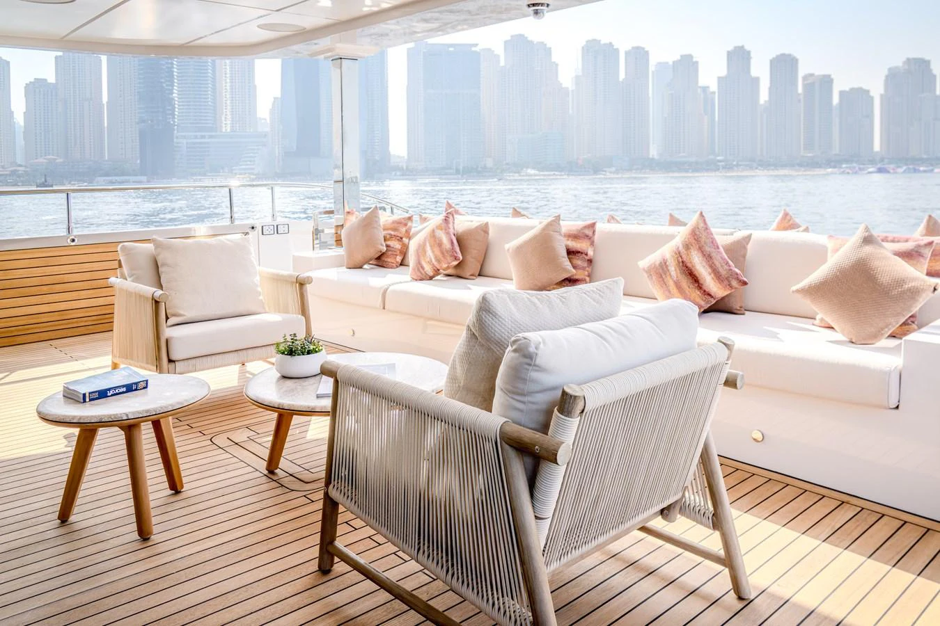 The aft deck offers a luxurious seating area with plush cushions and a stunning cityscape view. aboard MAJESTY 100 TERRACE Yacht for Sale