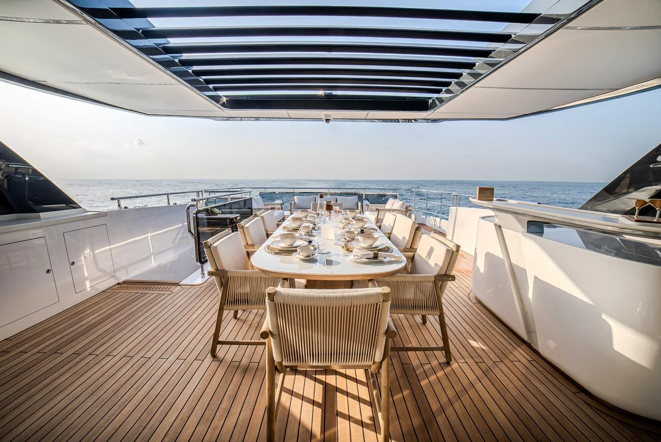 The aft deck features an elegant dining area with a stunning ocean view. aboard MAJESTY 100 TERRACE Yacht for Sale