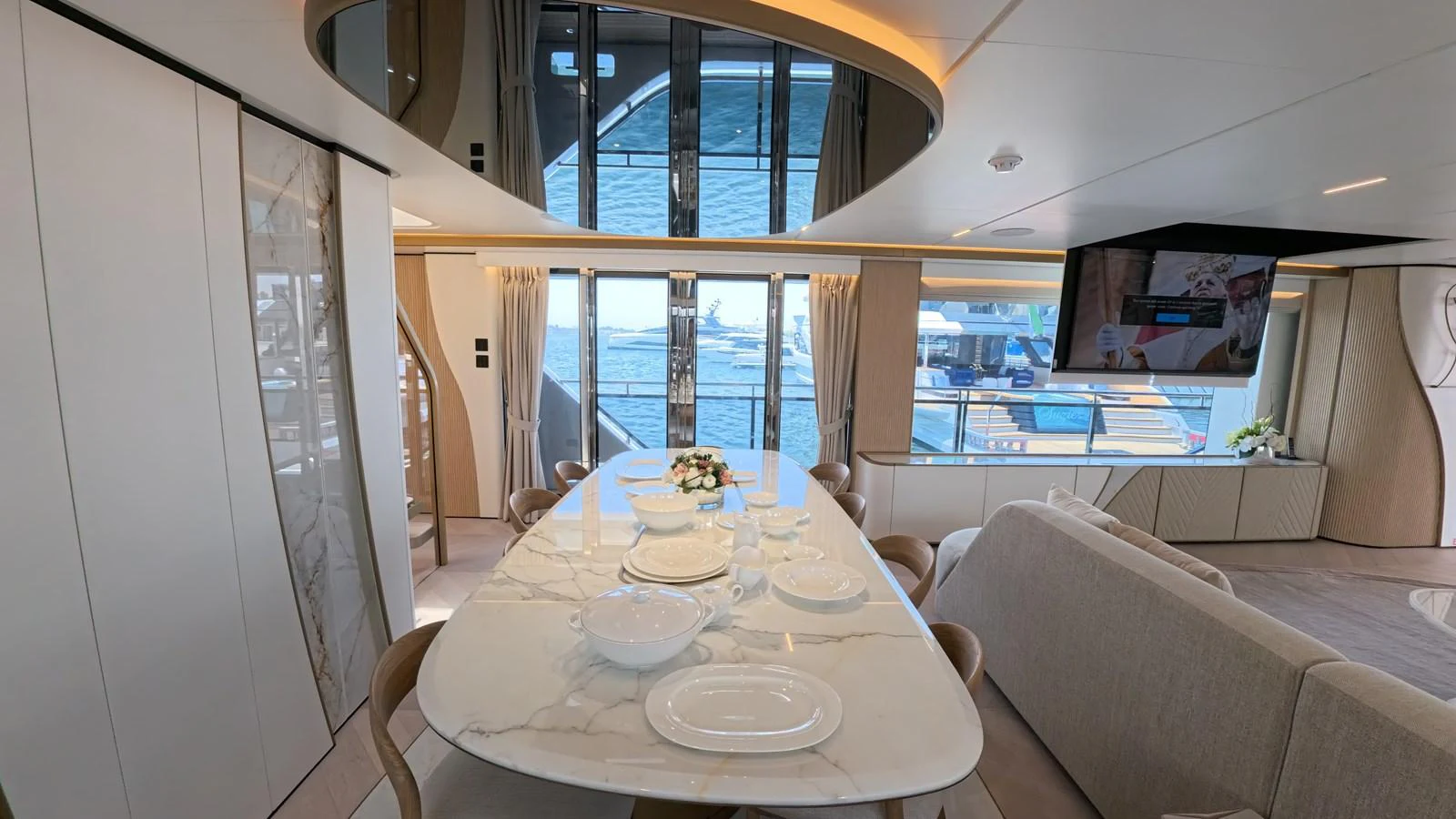 The yacht's dining area features a sleek, modern design with a large table set for a meal, offering a view of the water through expansive windows. aboard MAJESTY 100 TERRACE Yacht for Sale