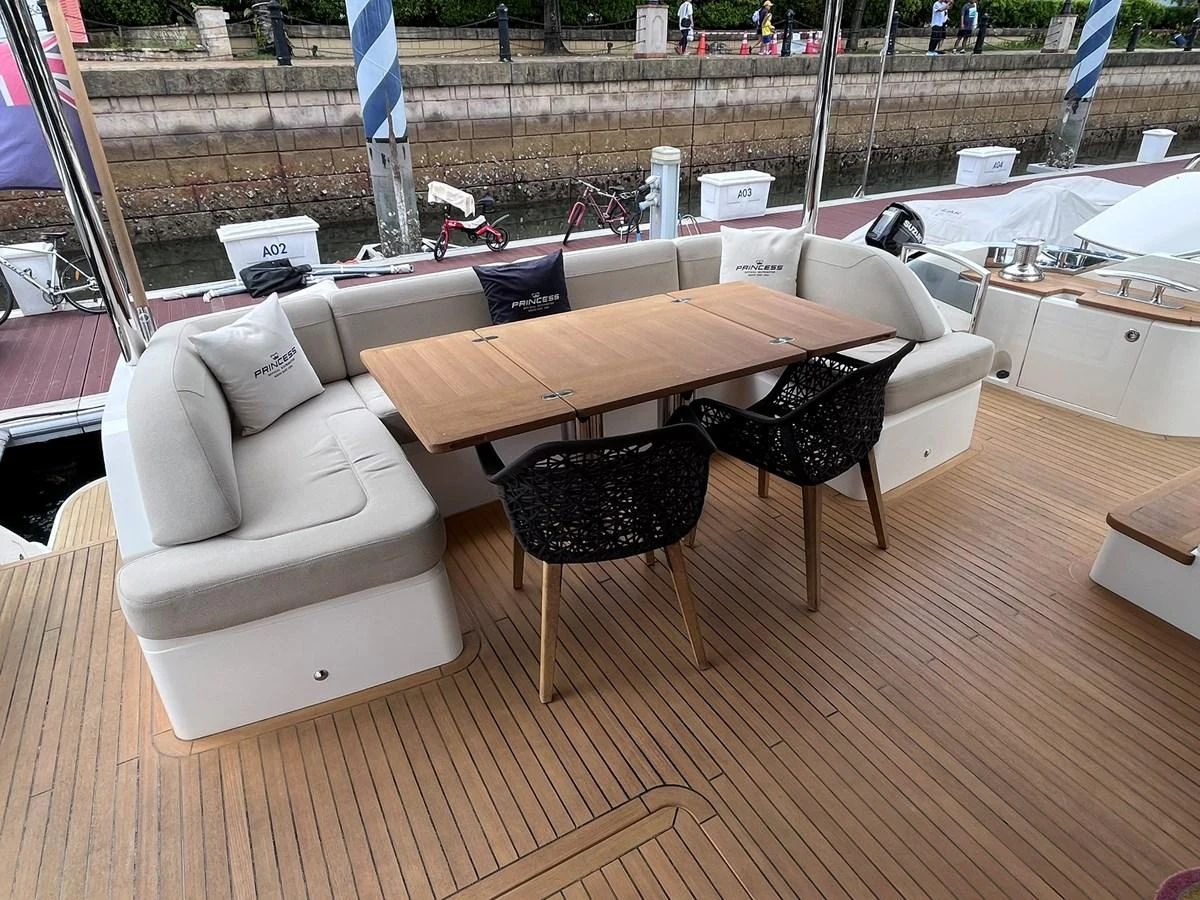 The aft deck features a comfortable seating area with a wooden table, perfect for outdoor dining and relaxation. aboard PRINCESS CHLOE Yacht for Sale