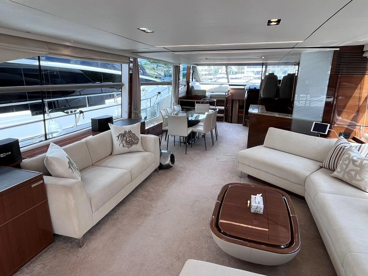 The spacious salon features elegant seating and a dining area with large windows offering scenic views. aboard PRINCESS CHLOE Yacht for Sale