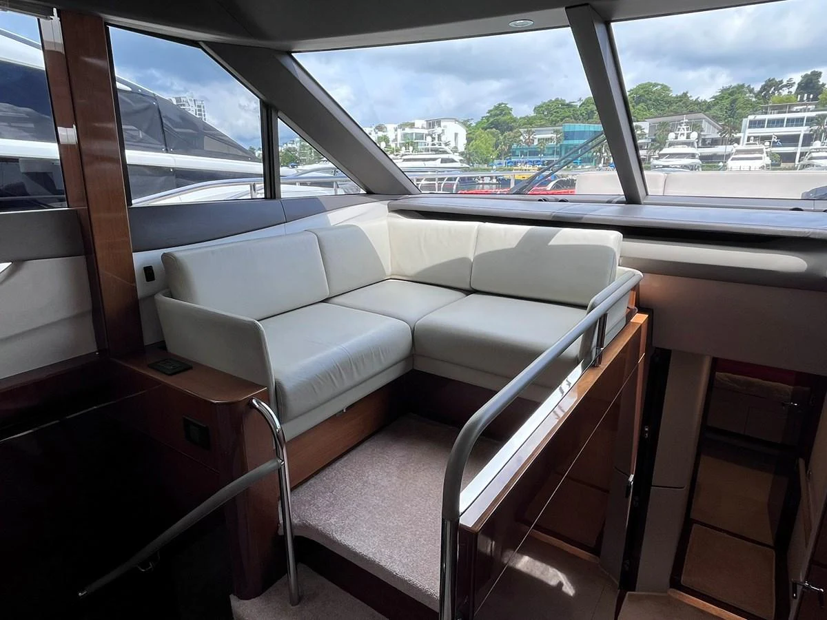 The salon features a cozy seating area with large windows offering a view of the marina. aboard PRINCESS CHLOE Yacht for Sale