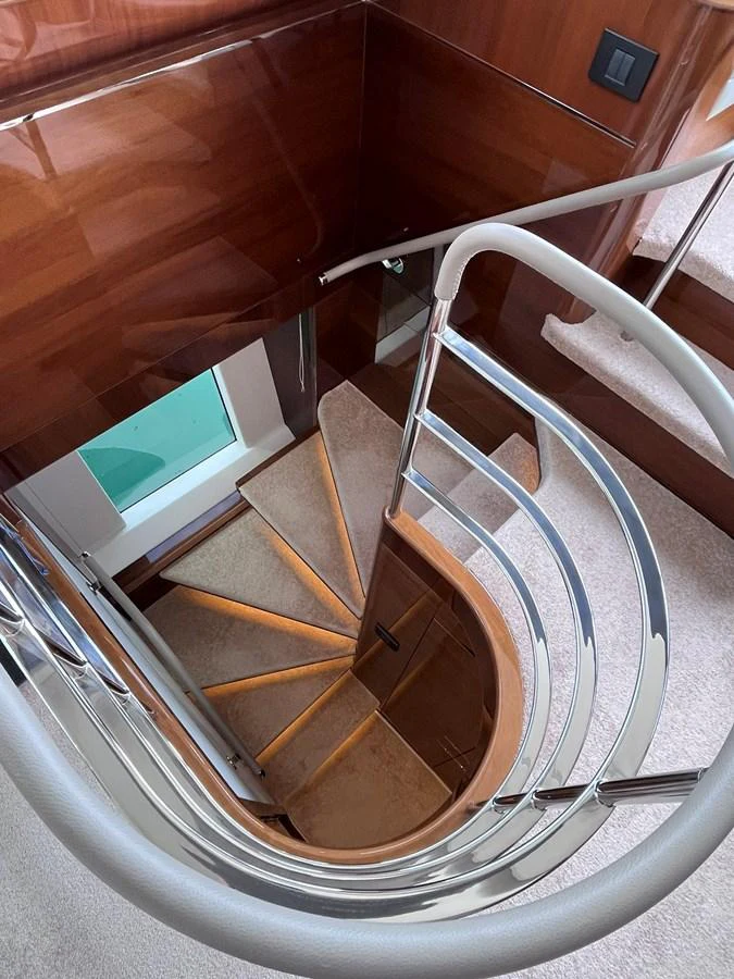 A beautifully crafted staircase with polished wood and sleek metal railings. aboard PRINCESS CHLOE Yacht for Sale