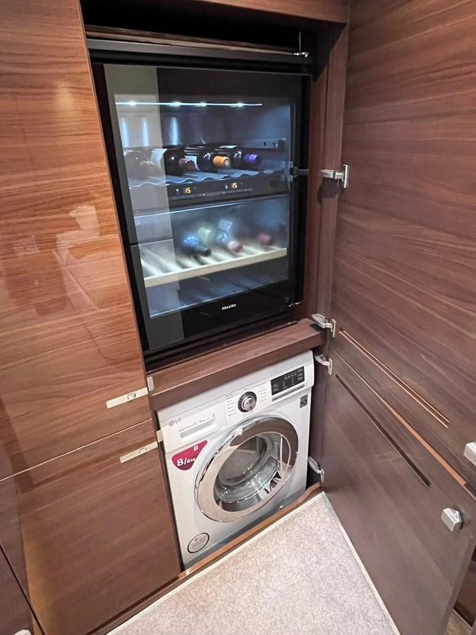 This yacht features a compact laundry area with a washing machine and a wine cooler. aboard PRINCESS CHLOE Yacht for Sale