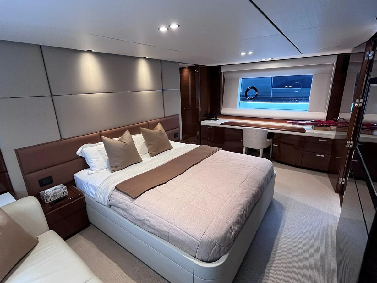 The stateroom features a luxurious bed with plush bedding and a large window offering a serene view. aboard PRINCESS CHLOE Yacht for Sale