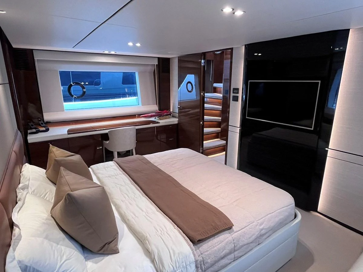 The stateroom features a luxurious bed, a desk area, and a flat-screen TV, creating a comfortable and elegant retreat. aboard PRINCESS CHLOE Yacht for Sale