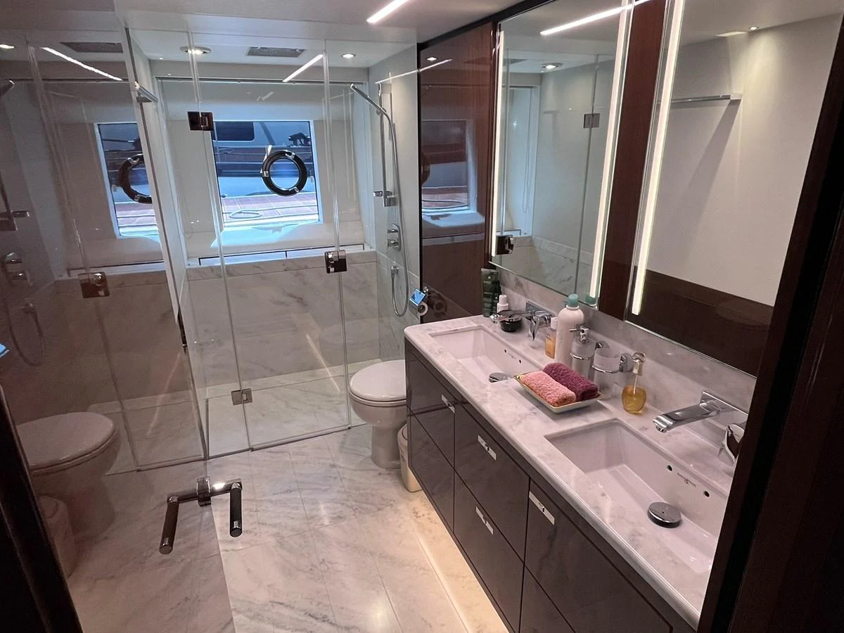 The yacht's bathroom features a sleek design with dual sinks and a spacious shower area. aboard PRINCESS CHLOE Yacht for Sale