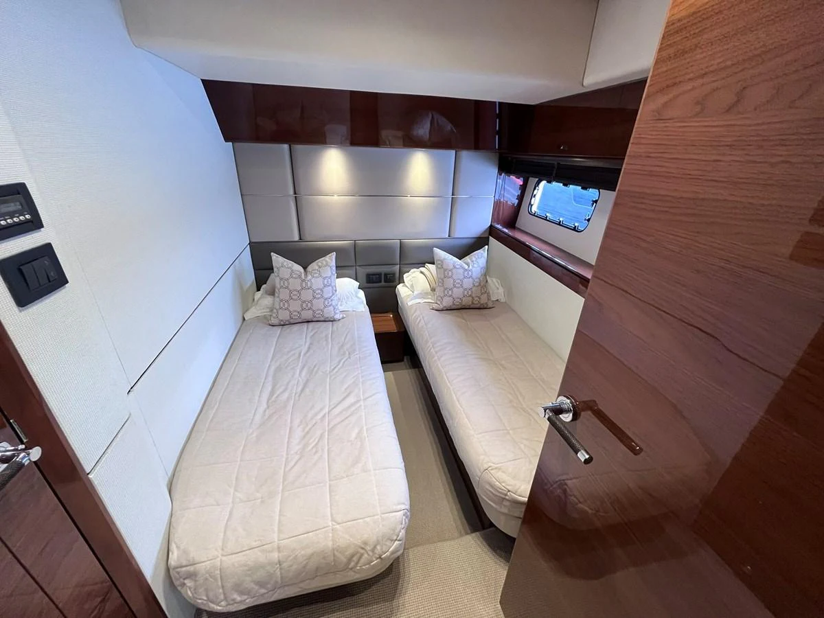 A cozy twin stateroom featuring two single beds with plush bedding and elegant wood paneling. aboard PRINCESS CHLOE Yacht for Sale