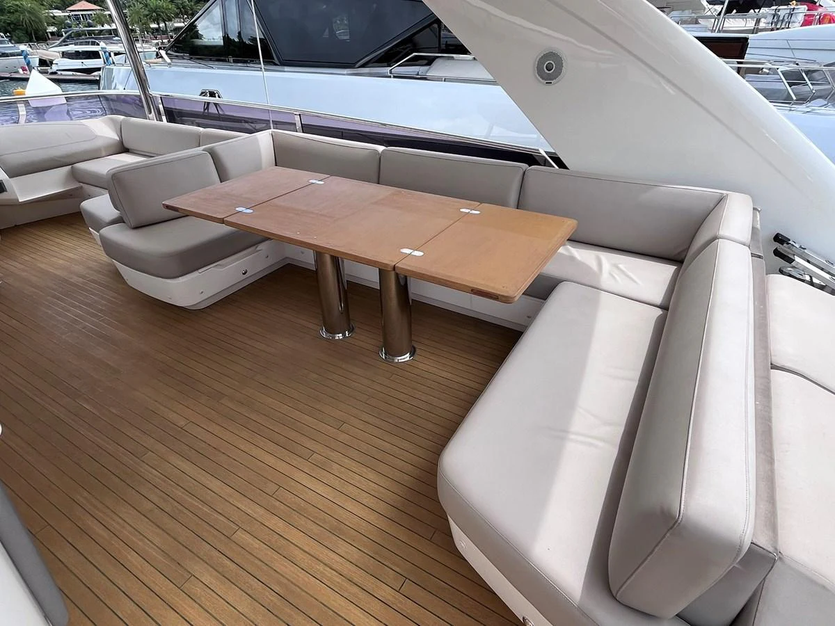 The aft deck features a spacious seating area with a wooden table, perfect for outdoor dining and relaxation. aboard PRINCESS CHLOE Yacht for Sale