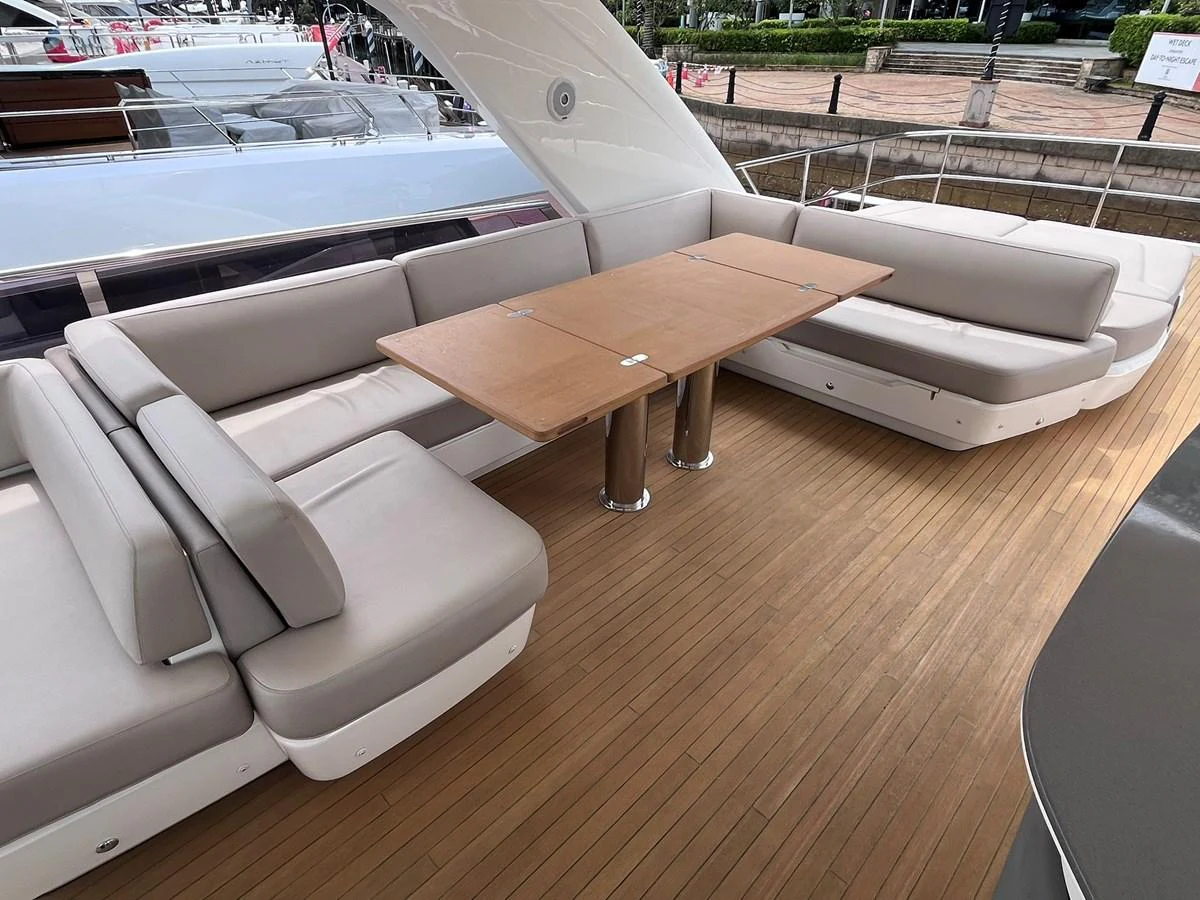 The aft deck features a spacious seating area with a central wooden table, perfect for outdoor dining and relaxation. aboard PRINCESS CHLOE Yacht for Sale