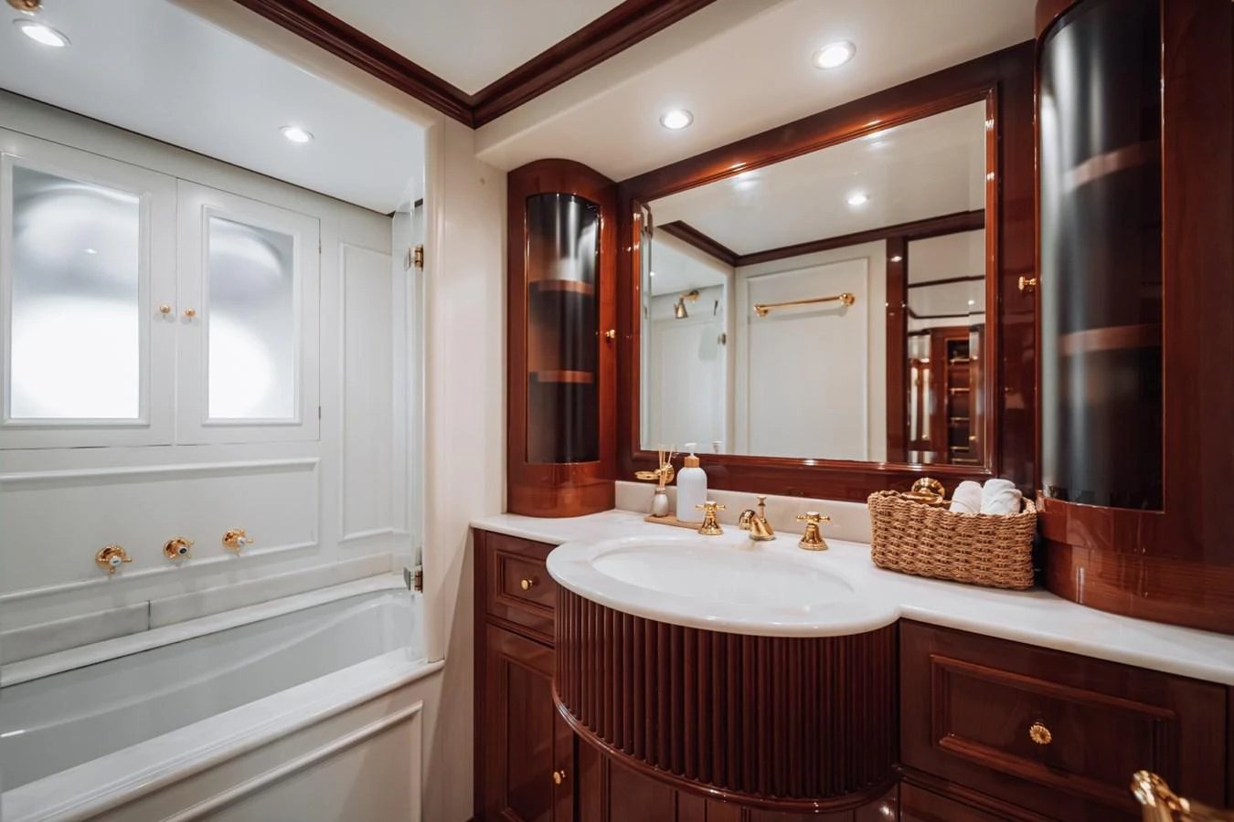 The yacht's bathroom features elegant wood finishes, a spacious bathtub, and luxurious fixtures. aboard GALLUS Yacht for Sale