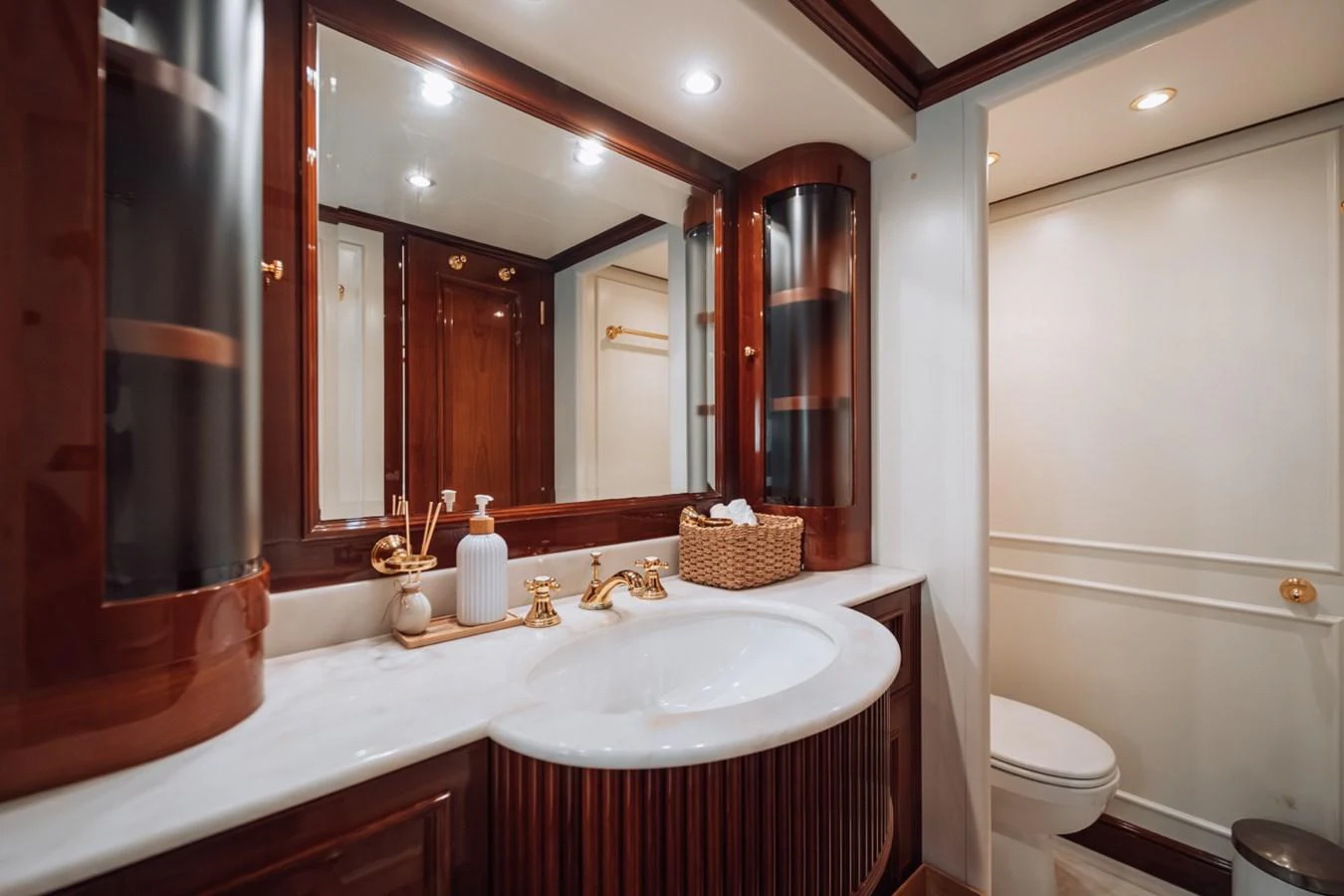 The yacht's bathroom features elegant wood finishes and luxurious fixtures. aboard GALLUS Yacht for Sale
