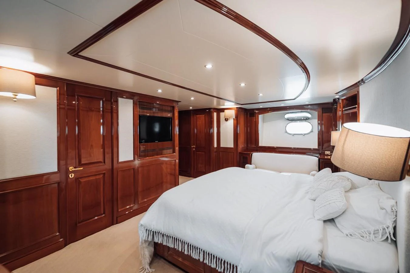 The master stateroom features elegant wood paneling and a plush bed, creating a luxurious and inviting atmosphere. aboard GALLUS Yacht for Sale