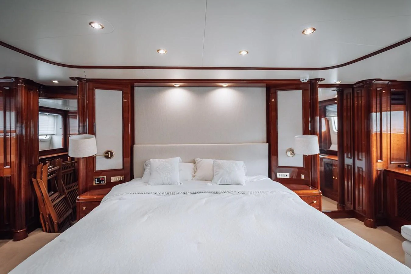 The master stateroom features a luxurious bed with elegant wood paneling and ambient lighting. aboard GALLUS Yacht for Sale