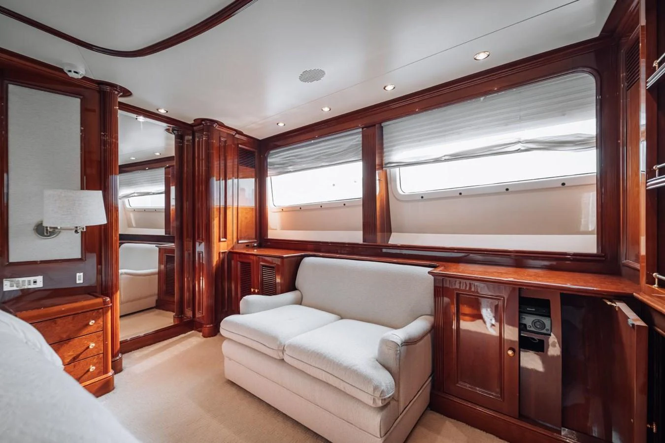 The salon features elegant wood paneling and comfortable seating, illuminated by natural light through large windows. aboard GALLUS Yacht for Sale