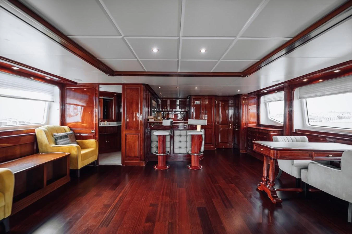 The yacht's salon features rich wood finishes, comfortable seating, and a well-appointed bar area. aboard GALLUS Yacht for Sale