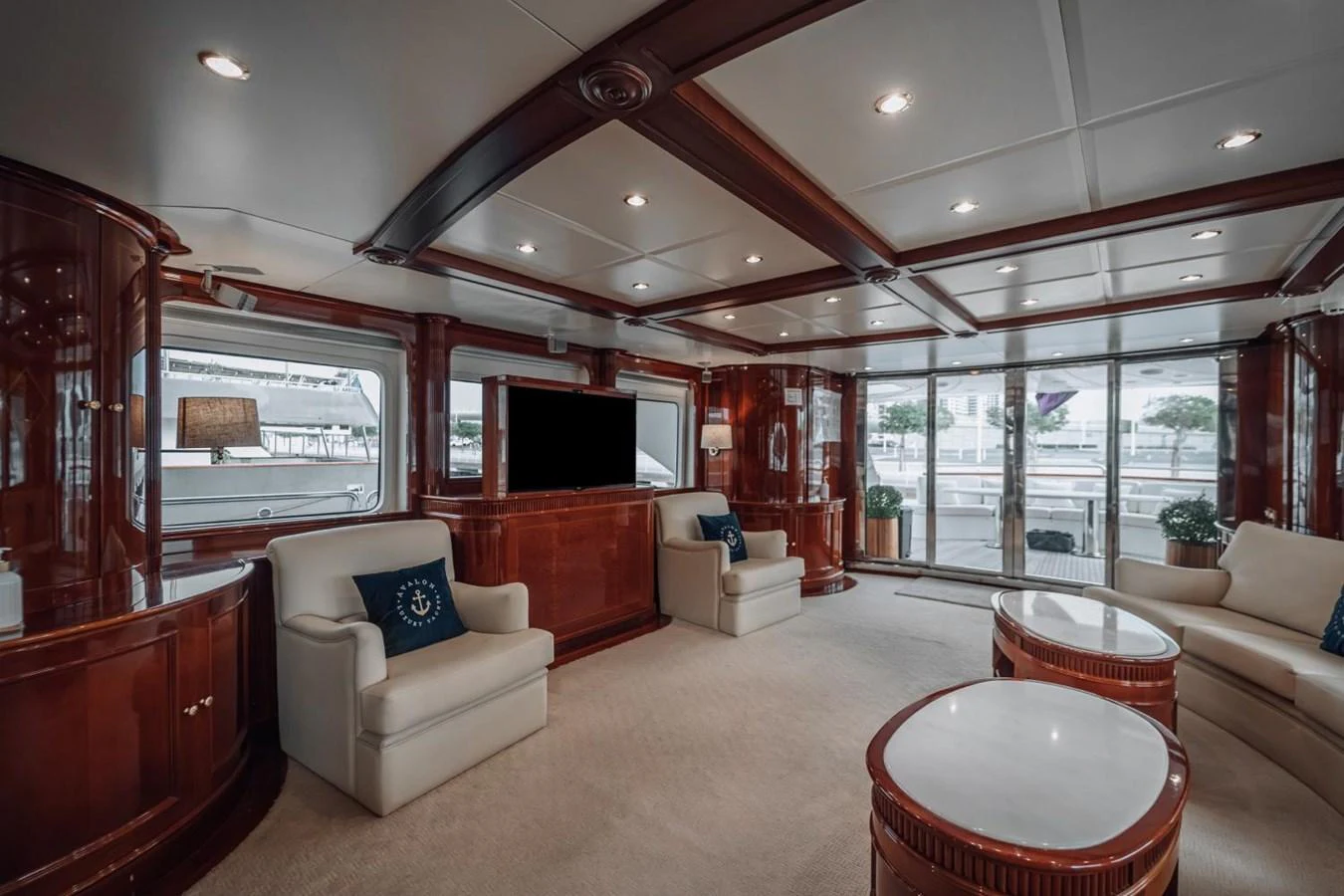The salon features elegant wood paneling, plush seating, and large windows offering ample natural light. aboard GALLUS Yacht for Sale
