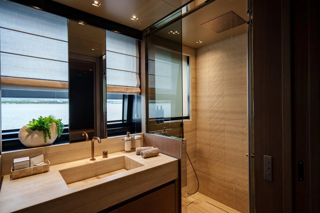 The yacht's bathroom features a sleek design with modern fixtures and a large window offering a view of the water. aboard DESTINO Yacht for Sale