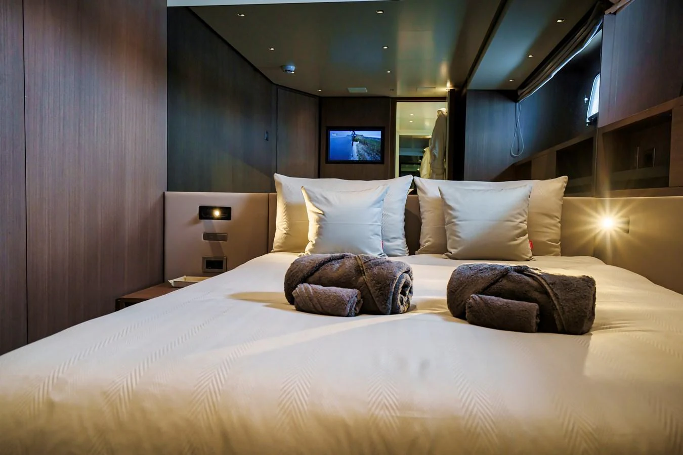 The stateroom features a plush bed with luxurious linens and ambient lighting, creating a serene retreat. aboard DESTINO Yacht for Sale