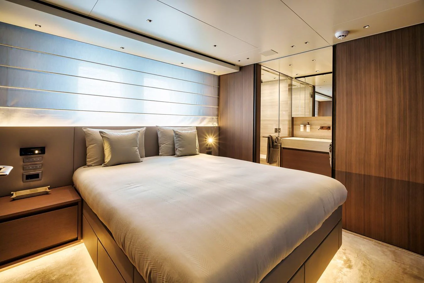 The master stateroom features a spacious bed, elegant wood paneling, and modern lighting. aboard DESTINO Yacht for Sale