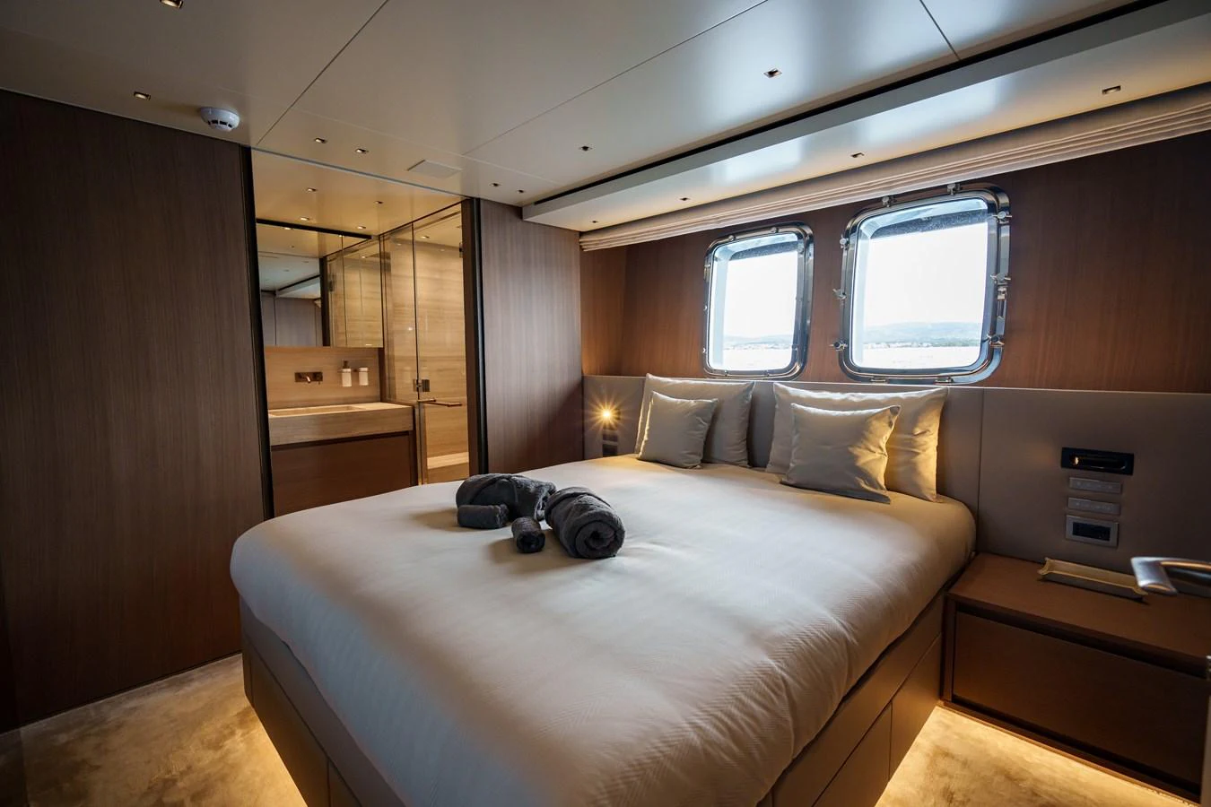 A luxurious stateroom featuring a large bed, modern lighting, and ample natural light from the windows. aboard DESTINO Yacht for Sale
