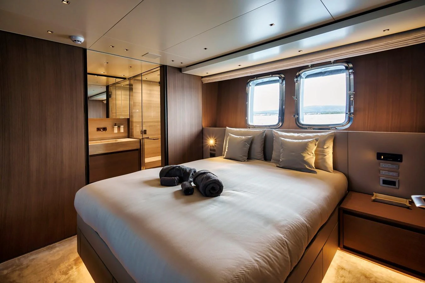The stateroom offers a luxurious and serene retreat with its plush bedding and elegant wood finishes. aboard DESTINO Yacht for Sale