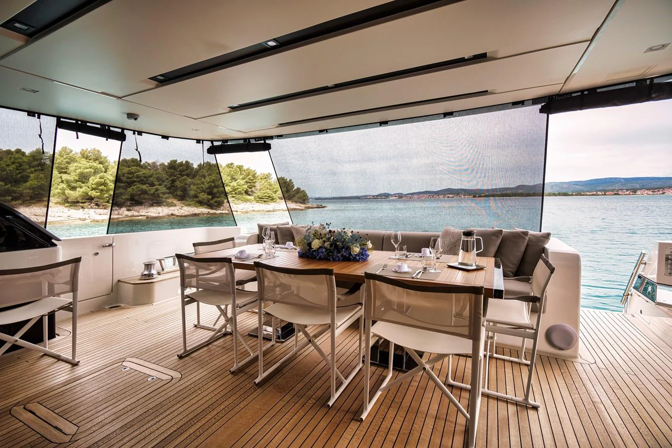 The aft deck features a stylish dining area with a beautiful view of the water. aboard DESTINO Yacht for Sale
