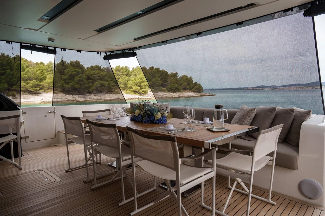The aft deck features an elegant dining area with a scenic view of the water and surrounding landscape. aboard DESTINO Yacht for Sale