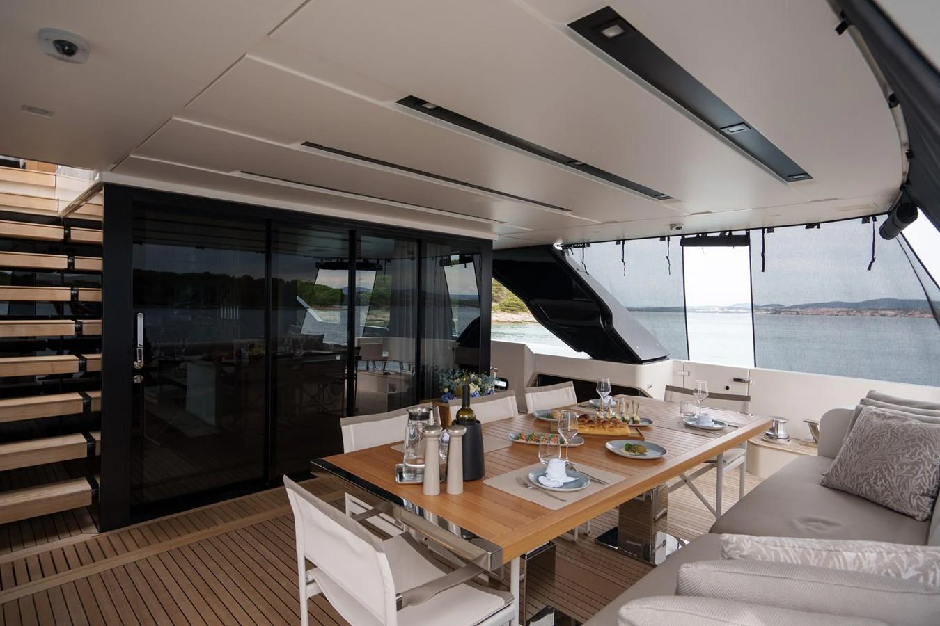 The aft deck features a spacious dining area with a large table and comfortable seating, perfect for enjoying meals with a view of the water. aboard DESTINO Yacht for Sale