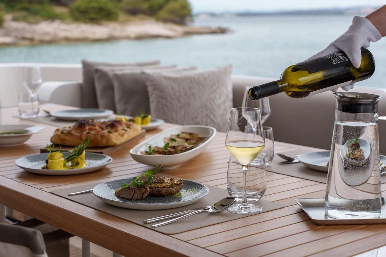 An elegant dining setup on the yacht's deck with a scenic view of the water. aboard DESTINO Yacht for Sale