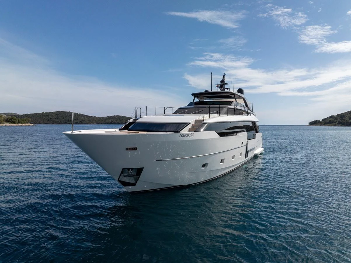 A sleek, modern yacht glides gracefully on calm waters under a clear sky. aboard DESTINO Yacht for Sale