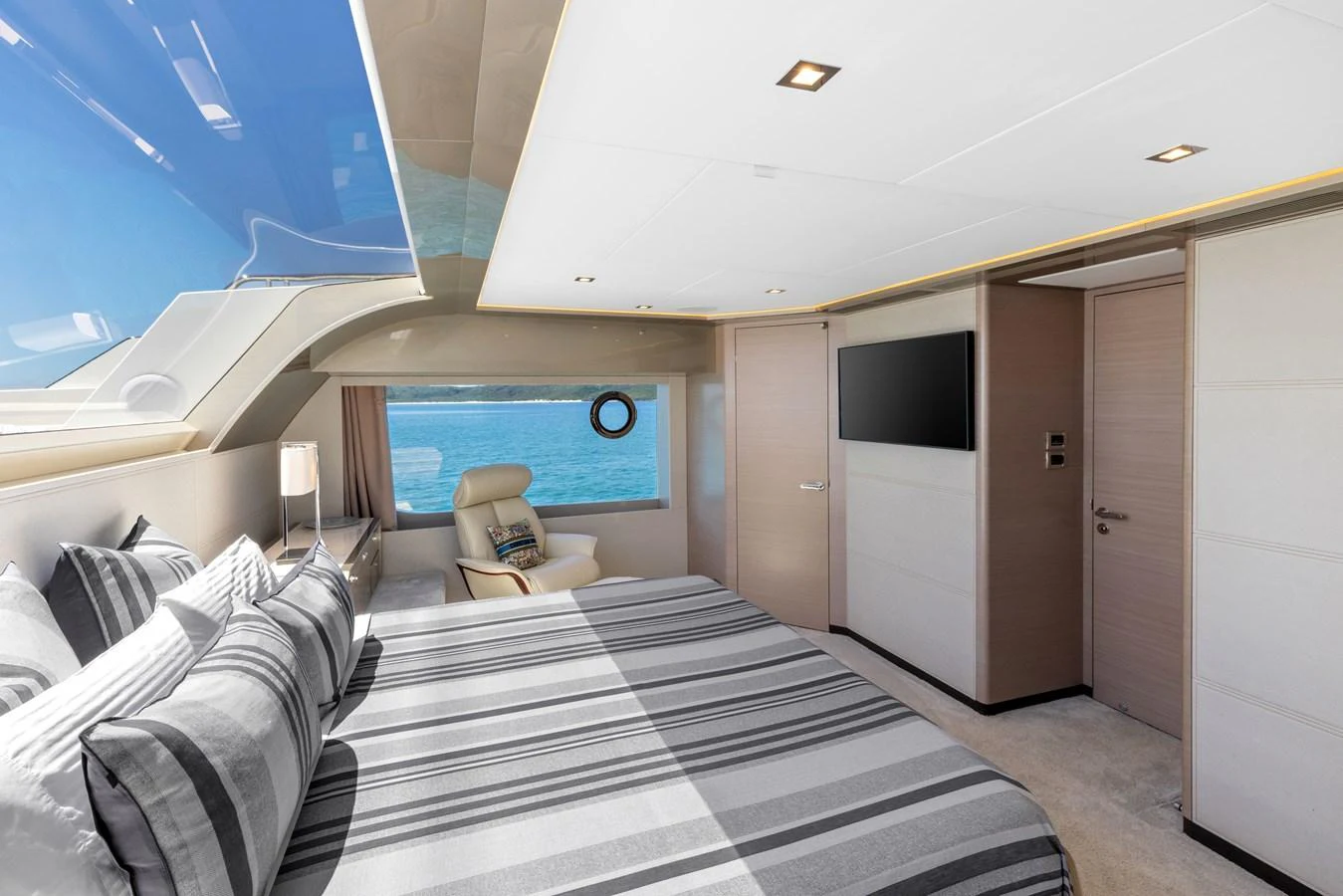 A luxurious stateroom with a large bed and a view of the sea through a window. aboard G Yacht for Sale