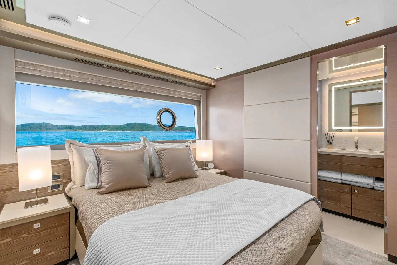 A luxurious stateroom with a large window offering a scenic view of the sea. aboard G Yacht for Sale