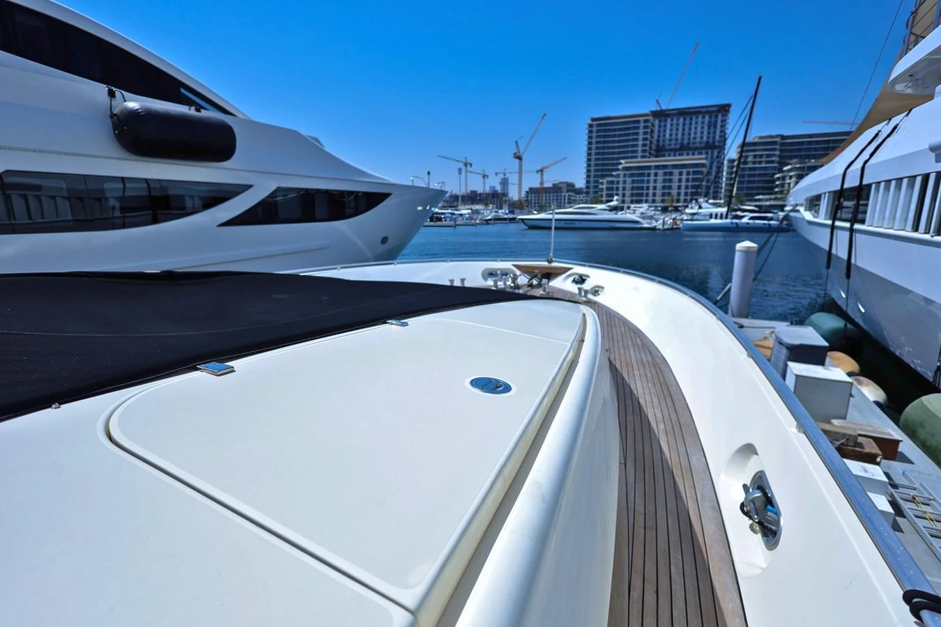 The yacht is docked in a marina, showcasing its sleek deck and nearby luxury vessels. aboard SEA SQUIRTER Yacht for Sale