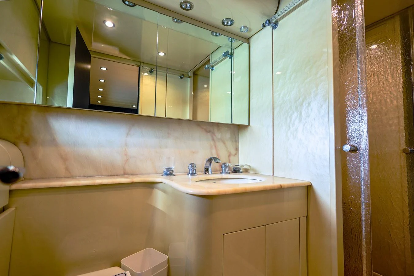 The yacht's bathroom features a sleek design with a marble countertop and mirrored cabinets. aboard SEA SQUIRTER Yacht for Sale