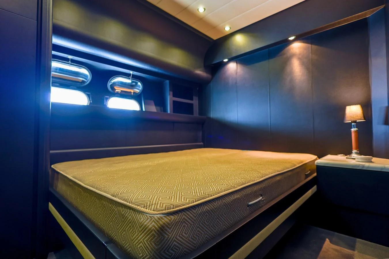 This stateroom features a luxurious bed with elegant lighting and modern design elements. aboard SEA SQUIRTER Yacht for Sale