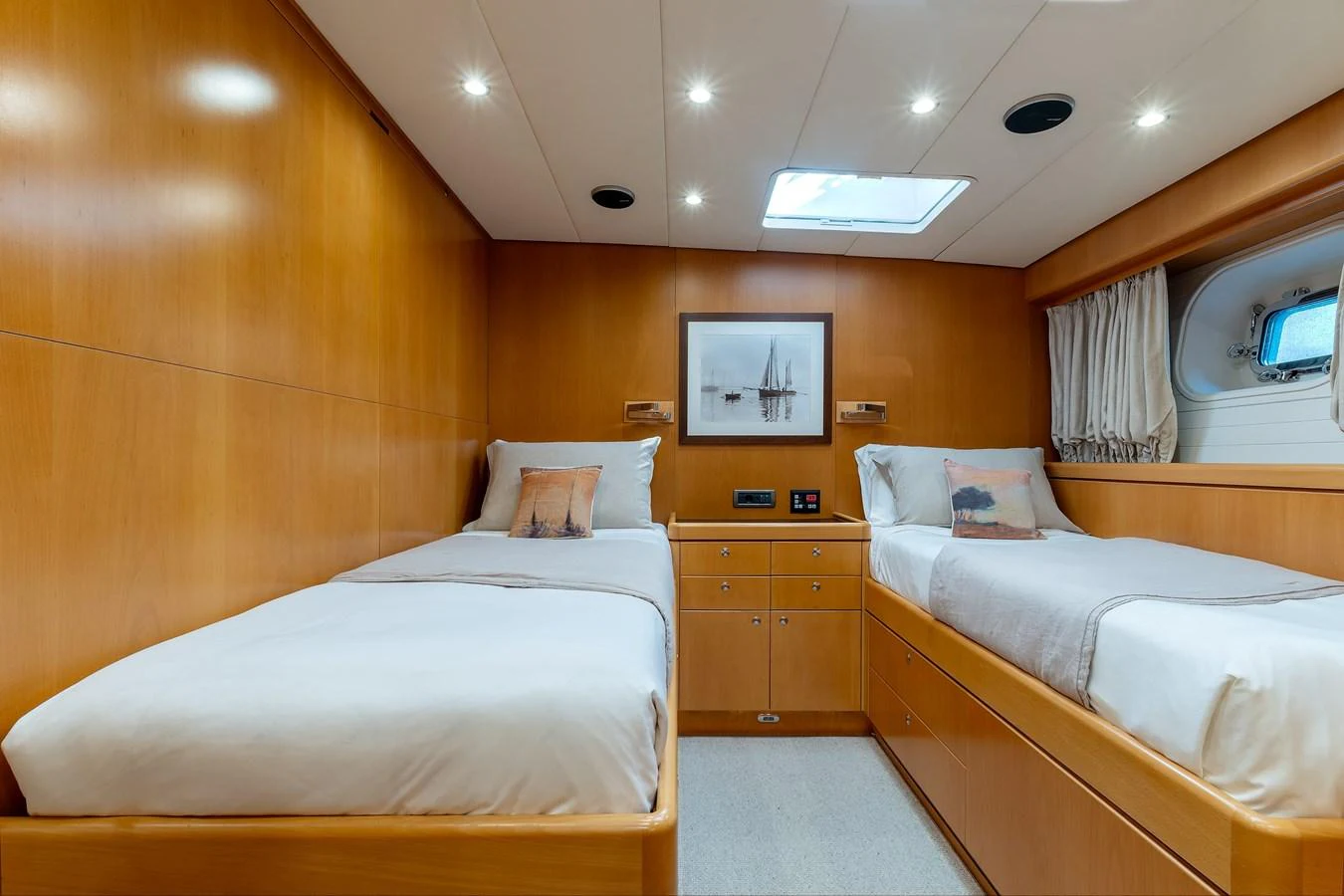The twin stateroom offers a cozy and inviting space with warm wood finishes and soft lighting. aboard EPIPHANY Yacht for Sale