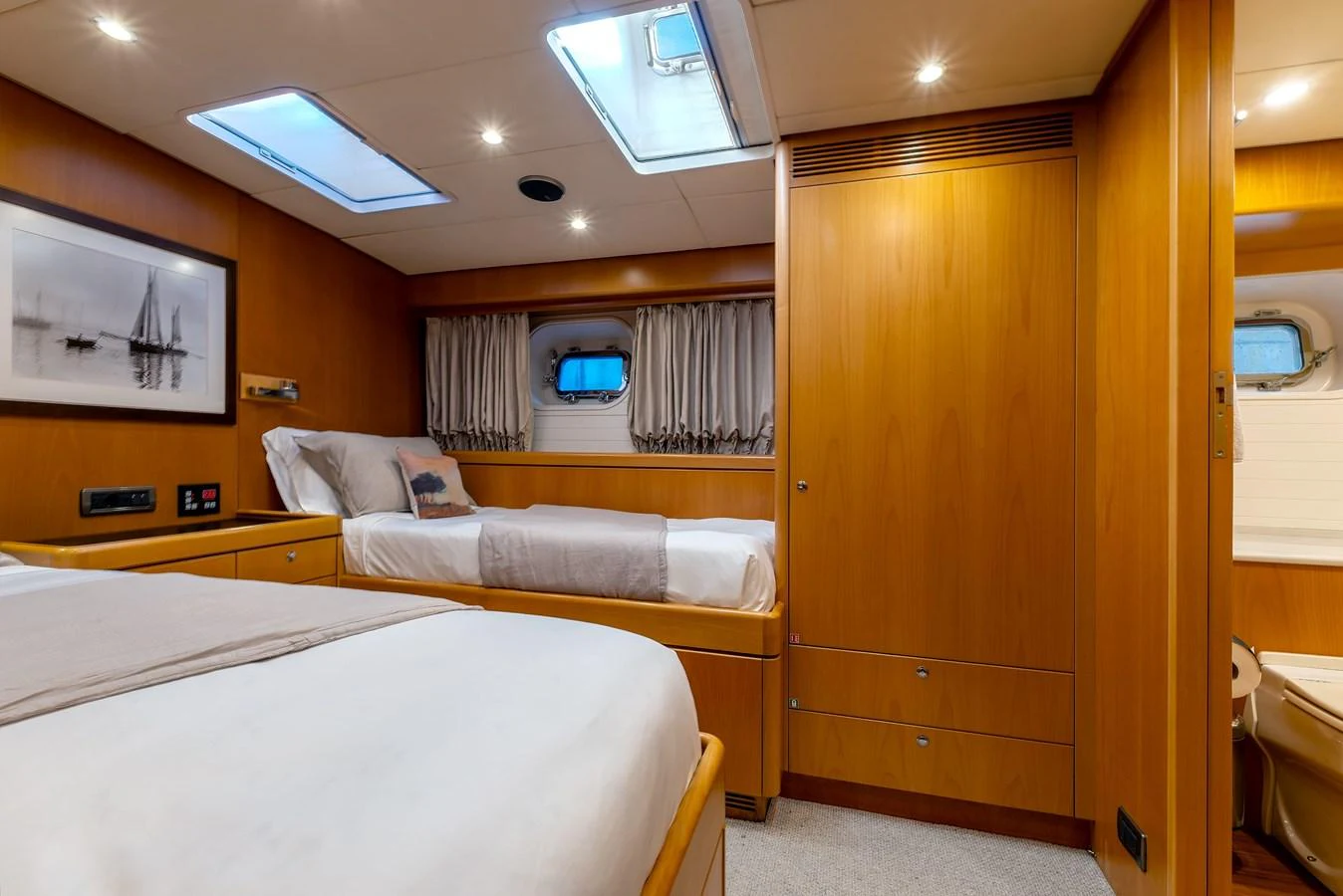 A cozy guest stateroom featuring twin beds, warm wood paneling, and ample natural light. aboard EPIPHANY Yacht for Sale