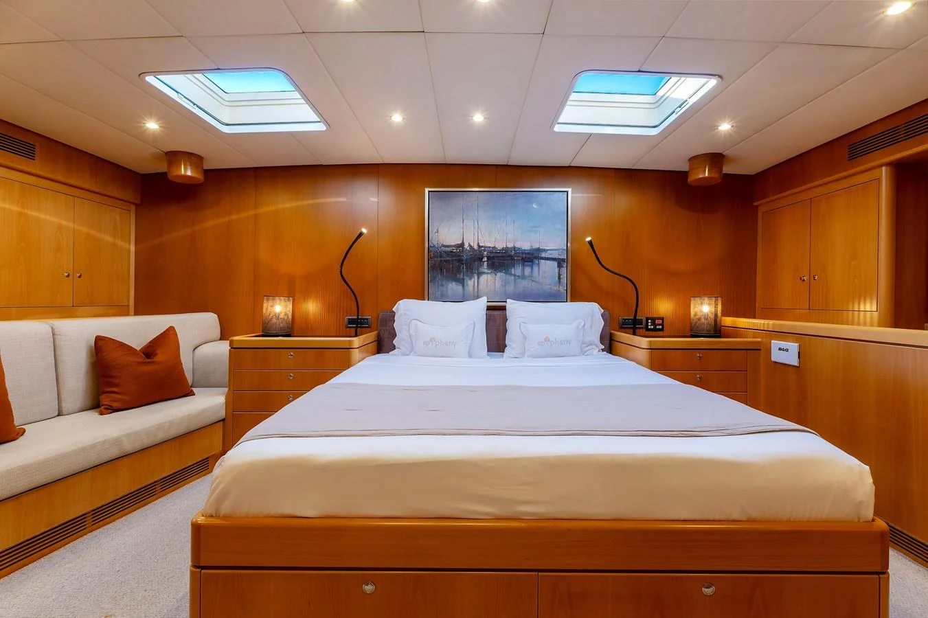 The master stateroom features a spacious bed, warm wood paneling, and ample natural light from overhead skylights. aboard EPIPHANY Yacht for Sale