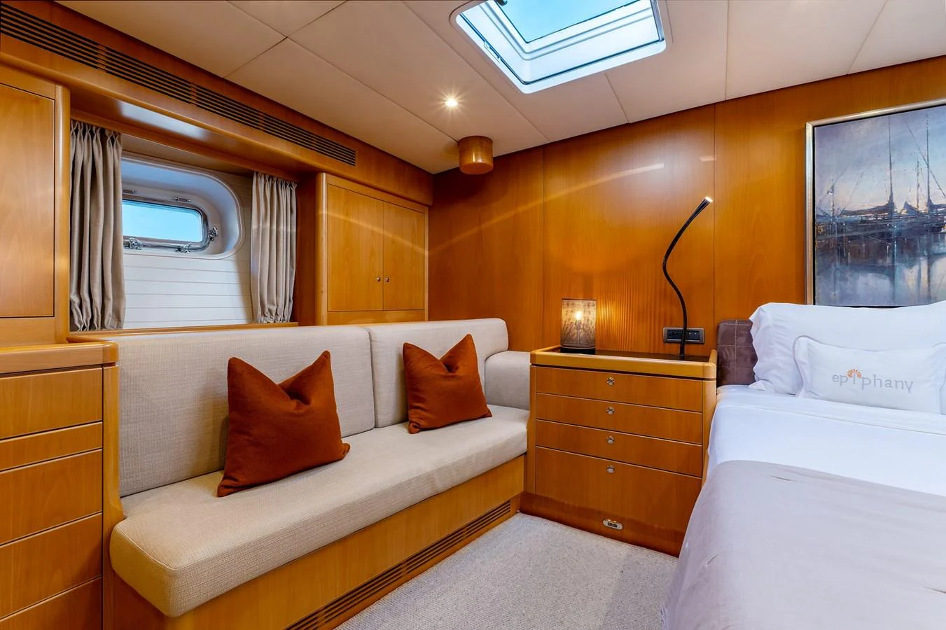 The stateroom features warm wood paneling, a comfortable sofa, and a cozy bed, creating a welcoming and elegant atmosphere. aboard EPIPHANY Yacht for Sale