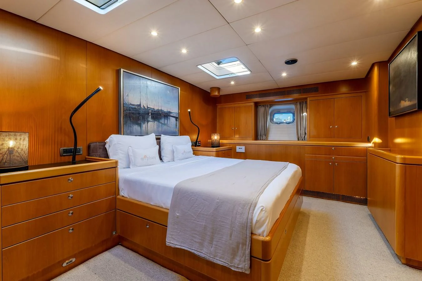 The master stateroom features a spacious bed, warm wood paneling, and ample natural light. aboard EPIPHANY Yacht for Sale
