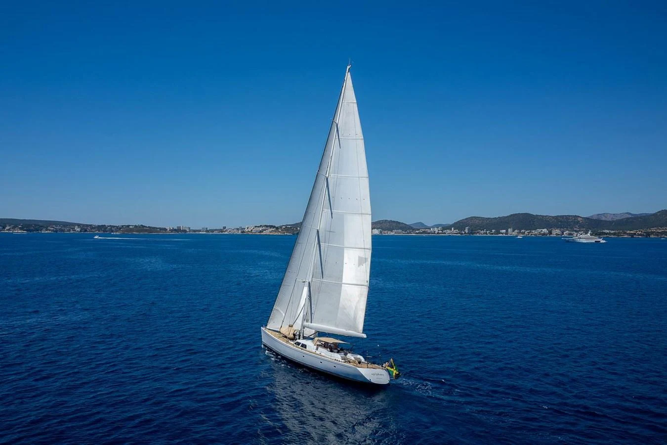 A sleek sailing yacht glides gracefully on the open sea under a clear blue sky. aboard EPIPHANY Yacht for Sale